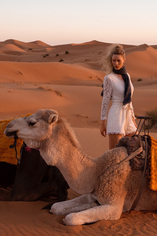 An attractive young woman riding a camel, Morocco Sahara desert