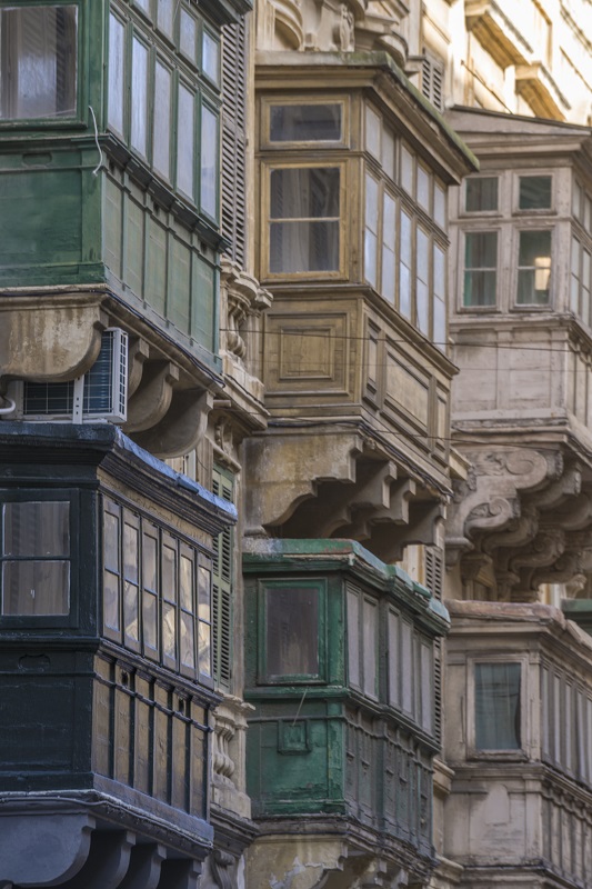 Traditional Maltese Balconies on a facade, stone wall and Maltese architecture